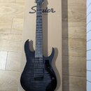 Černá elektrická kytara s dvojsekmovou hmatníkem a dvěma humbuckery, položená na kartonovém obalu. Na hlavě kytary je bílé logo Ibanez a na kartonu n…