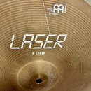 Zlatý kovový činel s koncentrickými drážkami. Na povrchu je bílý nápis LASER a pod ním text 14 CRASH. V horní části je logo MEINL s doplňujícím nápis…