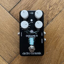 Černý efekt pedál s bílými ovládacími knoflíky. Na zařízení jsou nápisy FX LVL, TIME, MODE, TONE a v dolní části logo electro-harmonix. Uprostřed je…
