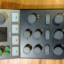 Černý audio mixér s nápisem MCaster STUDIO a logem výrobce. Zařízení obsahuje čtyři bílá tlačítka označená S1 až S4, několik otočných knoflíků a ovlá…