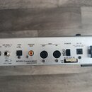 Záběr na zadní panel stříbrného efektového procesoru. Jsou zde viditelné nápisy AMP CONTROL, EXP PEDAL 2/ CTL 3, 4, USB, DIGITAL OUT, MIDI OUT a IN,…