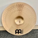 Kulatý mosazný činel s povrchem opatřeným drobnými vystupujícími důlky. V dolní části je černé logo s nápisem MEINL a velkým stylizedovaným písmenem…