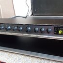 Černý rackový efektový procesor s řadou ovládacích knoflíků a přepínačů. Na panelu jsou viditelné nápisy sekcí INPUT-OUTPUT, MULTIEFFECT, REVERB a PR…