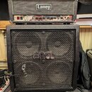 Fotografie zobrazuje kytarový stack složený z komba a boxu. Horní část tvoří zesilovač značky Laney s viditelným ovládacím panelem a přepínačem POWER…