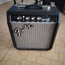 Černý kytarový kombo zesilovač s šedou textilní maskou reproduktoru. Na předním panelu je nápis Fender a označení modelu Frontman 10G s doplňkem FEND…