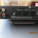 Zadní strana černého elektronického zařízení s nápisy SoundCan a MIDI SOUND GEN. Jsou zde vidět dva páry RCA konektorů označené jako INPUT a OUTPUT,…