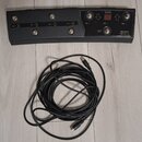 Černý nožní spínač z plastu s osmi kovovými tlačítky a červeným digitálním displejem. Na pravé straně je bílý nápis „Hughes & Kettner FSM-432 MK III“…