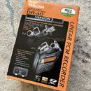 Krabice s nápisem TASCAM DR-40 VERSION 2 LINEAR PCM RECORDER. Na obalu je zobrazen černý digitální nahrávač s mikrofony v konfiguracích A-B a X-Y. V…