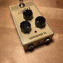 Krémový efekt pedál s kovovým šasi a třemi černými oválnými ovladači. Na horní straně je nápis „TRUE BYPASS“, „SPRING REVERB“ a logo „tc electronic“.…