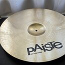Kruhový činel z mosazného kovu s viditelným rýhováním povrchu. V dolní části je černý nápis pAiste a pod ním menší text MADE IN SWITZERLAND. Povrch j…