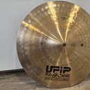 Zlatavý kovový činel s kmitacími důlky v horní části. Na povrchu je černý nápis Rough Series, EARCREATED CYMBALS a logo UFIP. V horní části je čiteln…