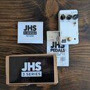 Bílý kytarový efekt s nápisem REVERB a logem JHS 3 SERIES. Na horní straně jsou tři černé otočné knoflíky s popisky VERB, EQ a DECAY. Vedle efektu je…