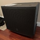 Černý subwoofer v hranatém korpusu s kovovou ochrannou mřížkou přes celý přední panel. V dolní části mřížky je umístěno logo JBL. Povrch korpusu má s…