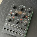 Černý modulární syntetizátor s nápisem CHAOS PACK a logem behringer v dolní části. Zařízení obsahuje několik otočných potenciometrů, tlačítka a řadu…