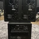 Tři černé reproduktory z řady POWERED SPEAKER SYSTEM značky YAMAHA. Dvě horní jednotky mají označení MODEL HS7 a spodní jednotka MODEL HS8. Na zadníc…