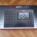 Krabice s produktem MPC LIVE II značky AKAI PROFESSIONAL. Na balení je zobrazen černý samplingový sekvencer s 16 RGB podsvícenými pady, displejem a o…