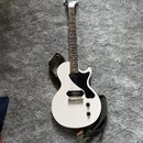 Bílá elektrická kytara s černým hmatníkem a černým plechtrátem. Na hlavě je viditelné logo Epiphone. Kytara má jeden humbucker, dva ovládací knoflíky…