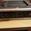 Kytarový zesilovač v hliníkovém kufru s černým povrchem. Na předním panelu je nápis RT2/50 MIDI Channel Switching Stereo Tube Power Amp a logo UP! na…