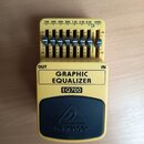Žlutý kytarový pedál s černým horním panelem. Na černém panelu je logo a nápis behringer, níže je uveden model EQ700 a text GRAPHIC EQUALIZER. Zaříze…