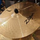 Zlatavý mosazný činel s viditelným rýhováním a klepaným povrchem. Na povrchu je černý nápis Zildjian a menší logo s nečitelným textem. Uprostřed je č…