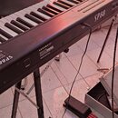 Černý digitální klavír s bílými a černými klávesami, umístěný na černém stojanu. Na korpusu je vidět bílý nápis SP88 a logo KURZWEIL®. V dolní části…