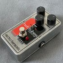 Kytarový efekt v kovovém šedém šasi s červeným panelem. Na panelu je bílý nápis hot tubes overdrive a v dolní části černý nápis electro-harmonix. Zař…