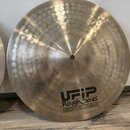 Kruhové činely z kovu s viditelným kladivováním po celém povrchu. Na spodní části je černý nápis UFIP Rough Series EARCREATED CYMBALS. V horní části…