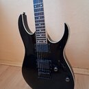Černá elektrická kytara s tmavým hmatníkem a bílým lemováním kolem korpusu. Nástroj má dva humbuckery, jeden ovládací potenciometr a přepínač. Povrch…