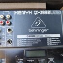 Detailní pohled na horní část mixážního pultu v šedé barvě. Na přístroji je bílý nápis XENYX QX1832USB a logo behringer. Pod ním se nachází sekce MUL…