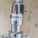 Detail chromovaného stojanu z kovu s pružinovým mechanismem. Na bílé nálepce je černý nápis MAPEX™ a pod ním menší text MADE IN CHINA. Povrch je lesk…
