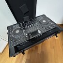 Černý DJ set složený ze dvou kontrolérů a mixéře, umístěný v černém transportním kufru s polstrováním. Na prostředním zařízení je viditelný nápis Pio…