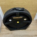 Černý plastový tvrdý kufýr na hudební nástroj s rukojetí. Na přední straně je žlutý obdélníkový štítek s nápisem HARDCASE. Vedle něj je malý žlutý št…