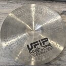 Kovový činel s povrchem pokrytým drobnými kmitočky. Na povrchu je černý nápis UFIP Rough Series EARCREATED CYMBALS. V horní části u středu je vyražen…