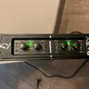 Černý rackový zesilovač s čtyřmi kanály označenými jako CH-A, CH-B, CH-C a CH-D. Na předním panelu jsou čtyři otočné ovladače, svítící zelené kontrol…