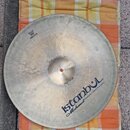 Kovový činel v stříbrné barvě s viditelnými stopami po kování. Na povrchu je nápis „istanbul Mehmet Handmade Cymbal from Turkey“ a v horní části ozna…