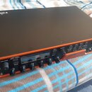 Oranžový kytarový procesor s černým horním krytem. Na předním panelu jsou nápisy POWER, VOLUME, SAVE, EDIT / BACK, SW 1, SW 2, SCROLL, FX LOOP, FX1,…