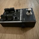 Černý kytarový pedál s kovovým šasi a stříbrným horním panelem. Na panelu je nápis HARMONIC BOOSTER CLEAN BASS PREAMP a v pravém okraji text DARKGLAS…