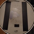 Fotografie znázorňuje bílý buben s kovovým obručem. Na membráně je nahoře černý nápis SONOR a dole logo REMO s textem UX DRUM HEAD a menším nápisem M…