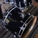 Černá bicí souprava tvořená basovým bubnem a dvěma tomami s chromovaným kováním. Na jednom z tomů je viditelné logo značky Gretsch. Povrch nástrojů j…