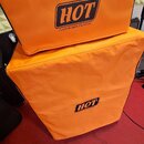 Dvě oranžové textilní kryty na zesilovače nebo reproduktory. Oba kryty mají černý lem a černo-bílé logo s nápisem HOT CUSTOM AMPLIFICATION. Povrch te…