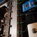 Stříbrný kytarový spínací pedalboard s nápisem STOMPCONTROL-4ISO a logem Harry Benson. Zařízení má čtyři stomečovací spínače, několik zapojených kabe…