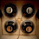 Fotografie zachycuje čtyři reproduktory osazené v dřevěné skříni. Každý reproduktor má na zadní straně štít s nápisy Celestion, MADE IN ENGLAND a ROL…