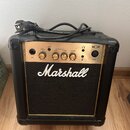 Černý kytarový kombo zesilovač značky Marshall, model MG10. Horní ovládací panel je zlatý s nápisy CLEAN VOLUME, GAIN, VOLUME a CONTOUR u odpovídajíc…