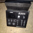 Černý elektronický bicí modul s nápisem NITRO MAX DRUM MODULE. Na přední straně jsou loga BFD a ALESIS DRUMS, symbol Bluetooth a ovládací prvky s pop…