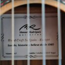Detail vnitřku akustické kytary s bílou štítkem. Na štítku je logo a nápisy Manuel Rodríguez guitarras, Hand Craft In Spain - Europe, Sonido, histori…
