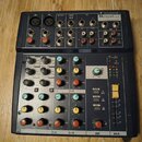 Černý mixovací pult značky Soundkraft, model Notepad 12 FX. Zařízení obsahuje několik vstupních kanálů s otočnými knoflíky v oranžové, žluté a modré…