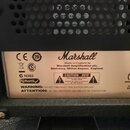 Detail štítku na zadní straně přístroje značky Marshall. Na štítku je nápis „Marshall“ a text „Made in England by Marshall Amplification plc, Bletchl…