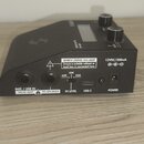 Černý kytarový efekt s ovládacími knoflíky a displejem. Na zadní straně jsou vstupy a výstupy s popisky INST. / LINE IN FROM AMP, TO SPEAKER, IN LEVE…