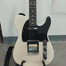 Bílá elektrická kytara typu Telecaster s černým plechtrádem. Nástroj má jeden humbukový snímač u kobylku a jeden jednoduchý snímač u krku. Na kytaru…