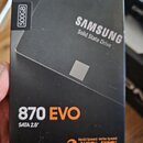 Fotografie znázorňuje krabici od SSD disku značky SAMSUNG s nápisem Solid State Drive. Na obalu je uveden model 870 EVO, kapacita 500GB a rozměr SATA…